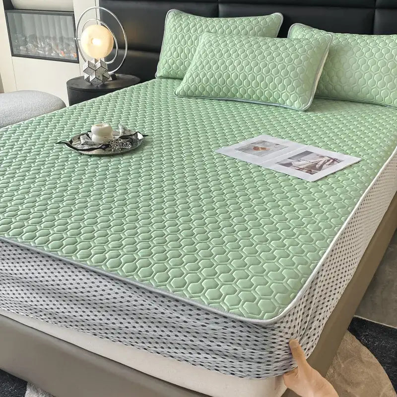 Light green hexagonal quilted mattress pad with white border in a light blue hexagonal ice silk cooling bed mat set