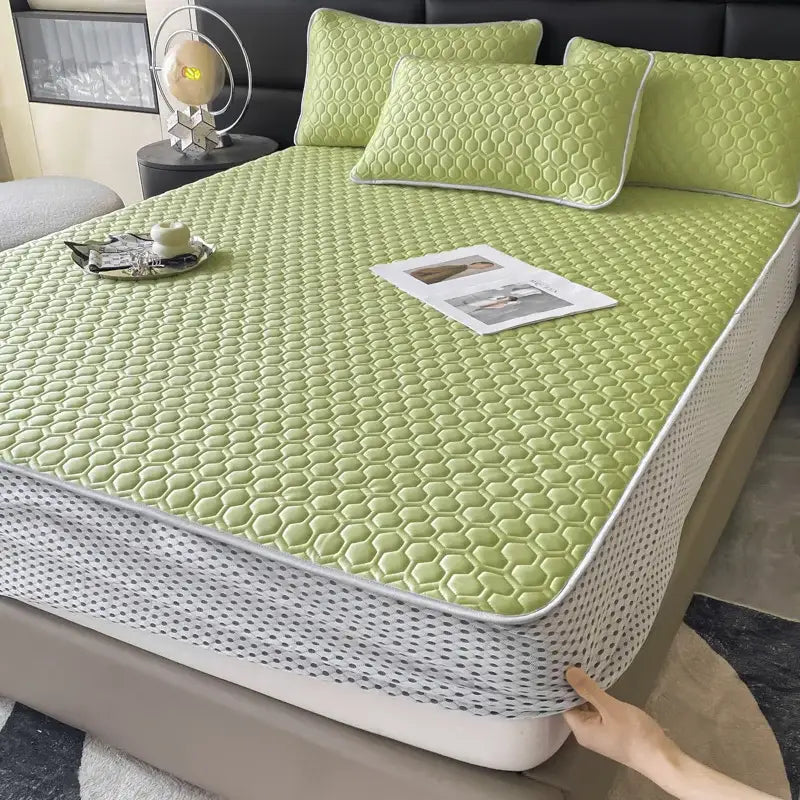 Light green hexagonal quilted bed mat with white piping and matching dotted edge for cooling bed mat set
