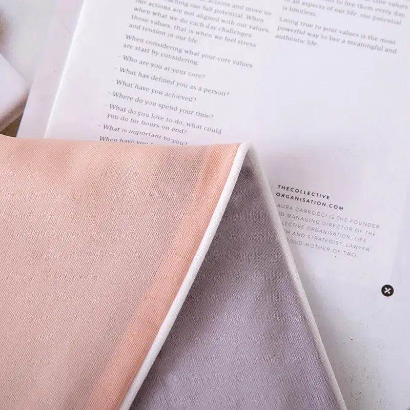 A soft peach fabric with subtle texture folded beside paper for a light blue ice cream air conditioning quilt bedroom blanket