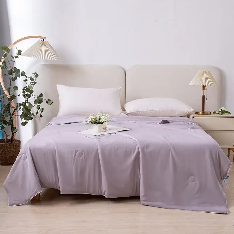 A soft lavender air conditioning quilt with subtle circular stitching ideal for light blue ice cream air summer use