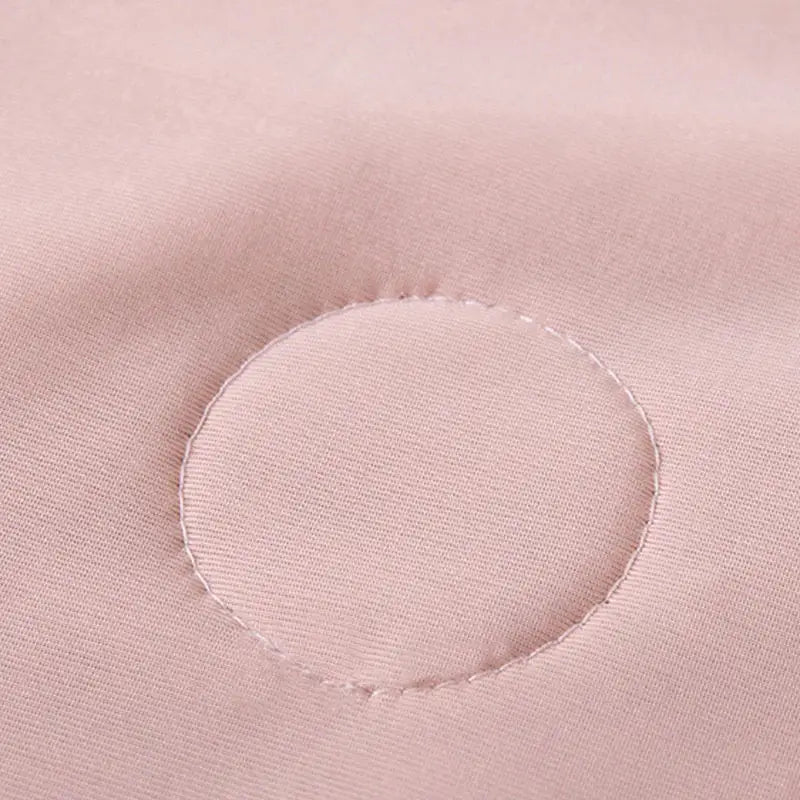 A soft pink quilted fabric with a circular stitched patch in a light blue ice cream air conditioning quilt for summer bedroom