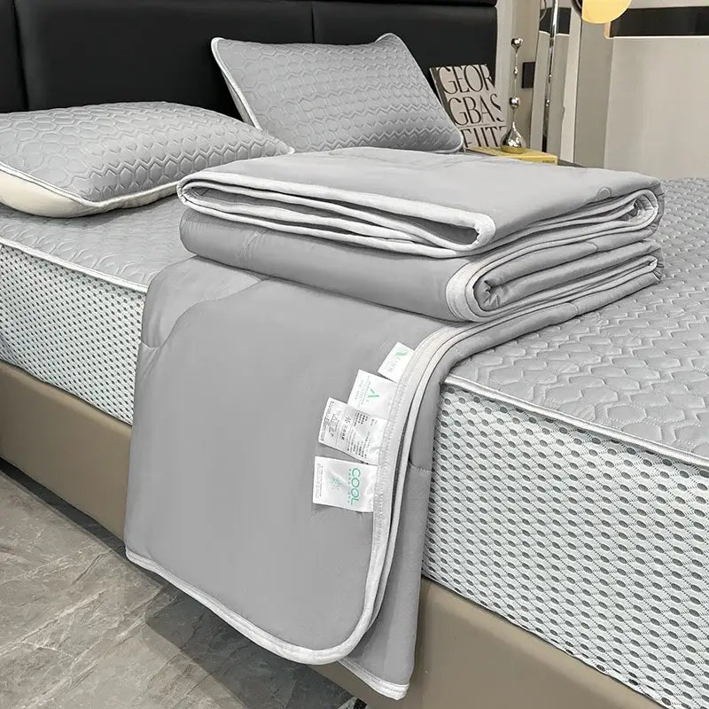 Gray quilted blanket with white piping and care tags in decorbites cool feeling ice silk quilt set for bedroom bedding