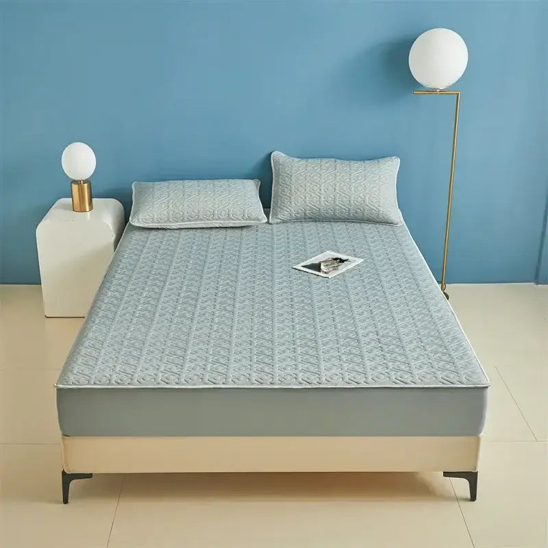 Light blue quilted latex fitted sheet set bed pad with subtle geometric pattern and stitched edges for bedroom use