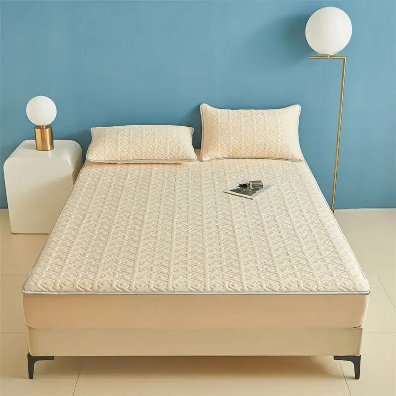 Cream-colored quilted mattress protector with subtle geometric pattern and stitched edges for fitted sheet set use