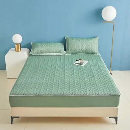 Light blue quilted latex fitted sheet set featuring a mint green quilted bed sheet with subtle geometric pattern and white piping