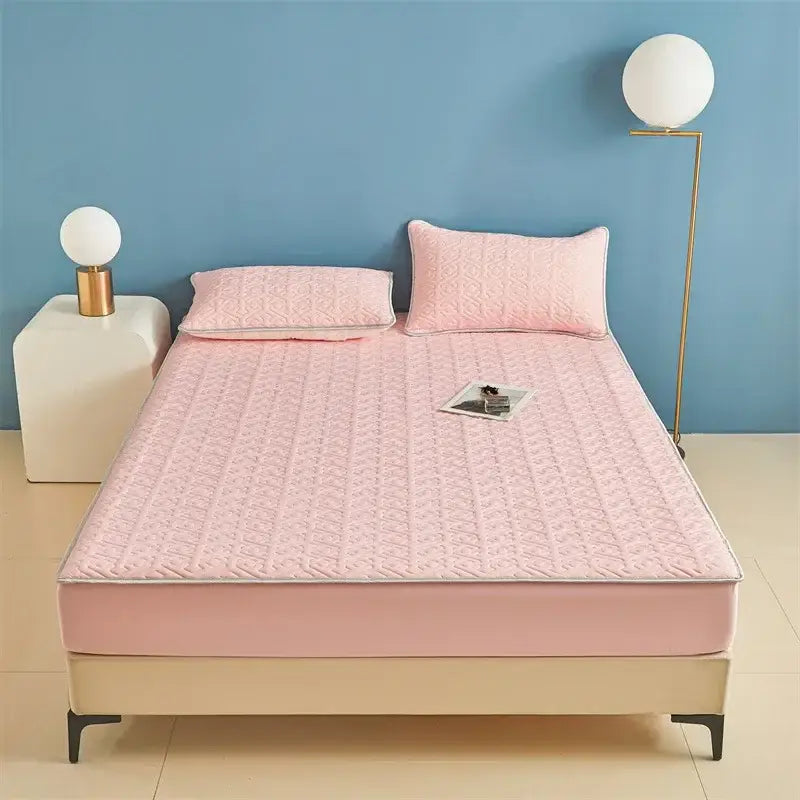 Pink quilted bedspread with subtle geometric pattern and matching pillowcases complement the fitted sheet set