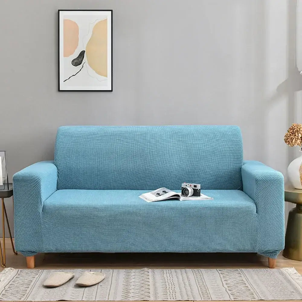 A light blue decorbites 3d quilted thicken sofa cover snugly fits a modern three-seater living room couch