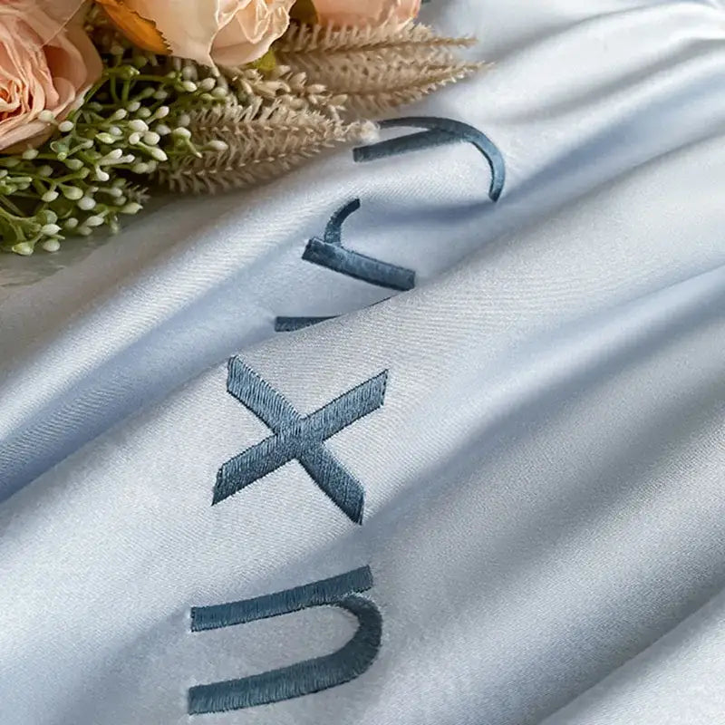 Light blue satin embroidery bedding set with dark gray embroidered lettering for bedroom decorbites collection