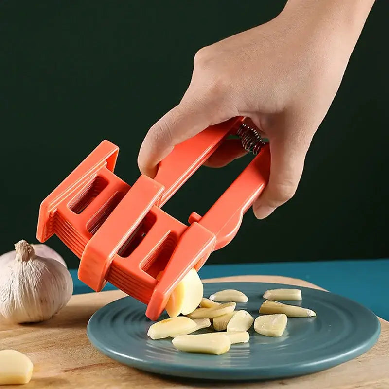 Bright orange plastic garlic press slicer with spring loaded mechanism for easy chopping in kitchen use