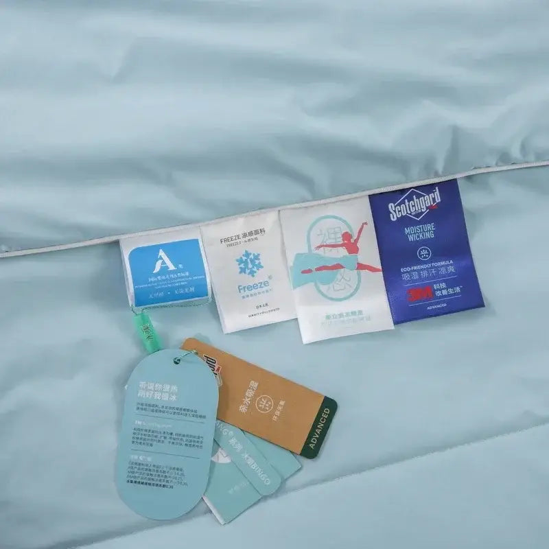 Light blue and white cooling fabric summer blanket comforter with quilted design, care tags, and decorbites cooling fabric sachets