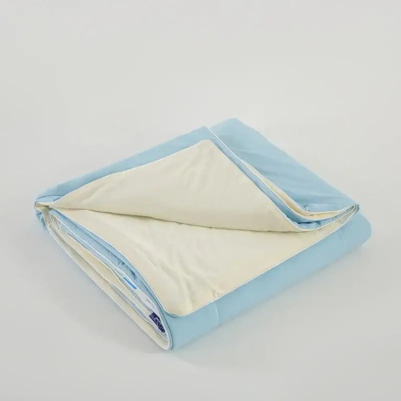 Light blue and cream-colored quilted bedroom comforter made with decorbites cooling fabric for summer use