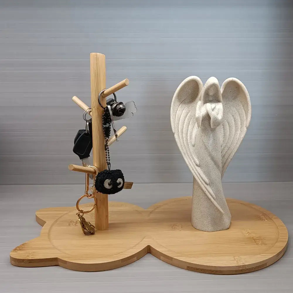 A light beige angel figurine on a wooden base serves as a decorative element for the light brown cat wooden key rack holder