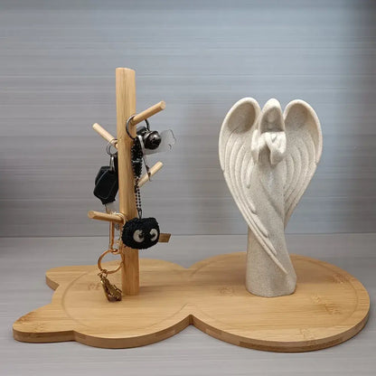 A light beige angel figurine on a wooden base serves as a decorative element for the light brown cat wooden key rack holder