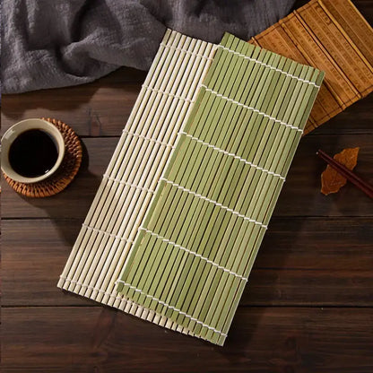 Two bamboo sushi rolling mats in natural beige and light green with white string bindings in a rolling mat set