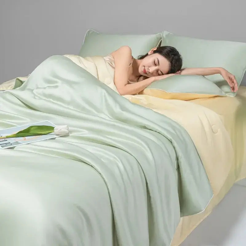 A woman sleeps peacefully under a light green and cream cool ice silk quilt set with subtle sheen decorbites cool ice