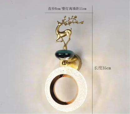 Gold-toned deer wall lamp with branching antlers on dark green ceramic orb and frosted glass shade by decorbites light luxury