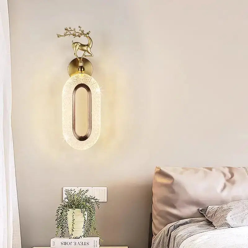 Gold-toned deer wall lamp with oval textured glass shade and polished metal frame for light luxury modern bedroom decorbites light luxury