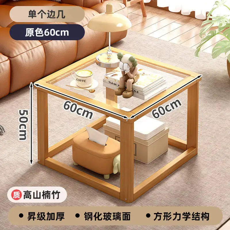 Light wood two tier coffee table set with transparent glass top and bamboo legs featuring open lower shelving