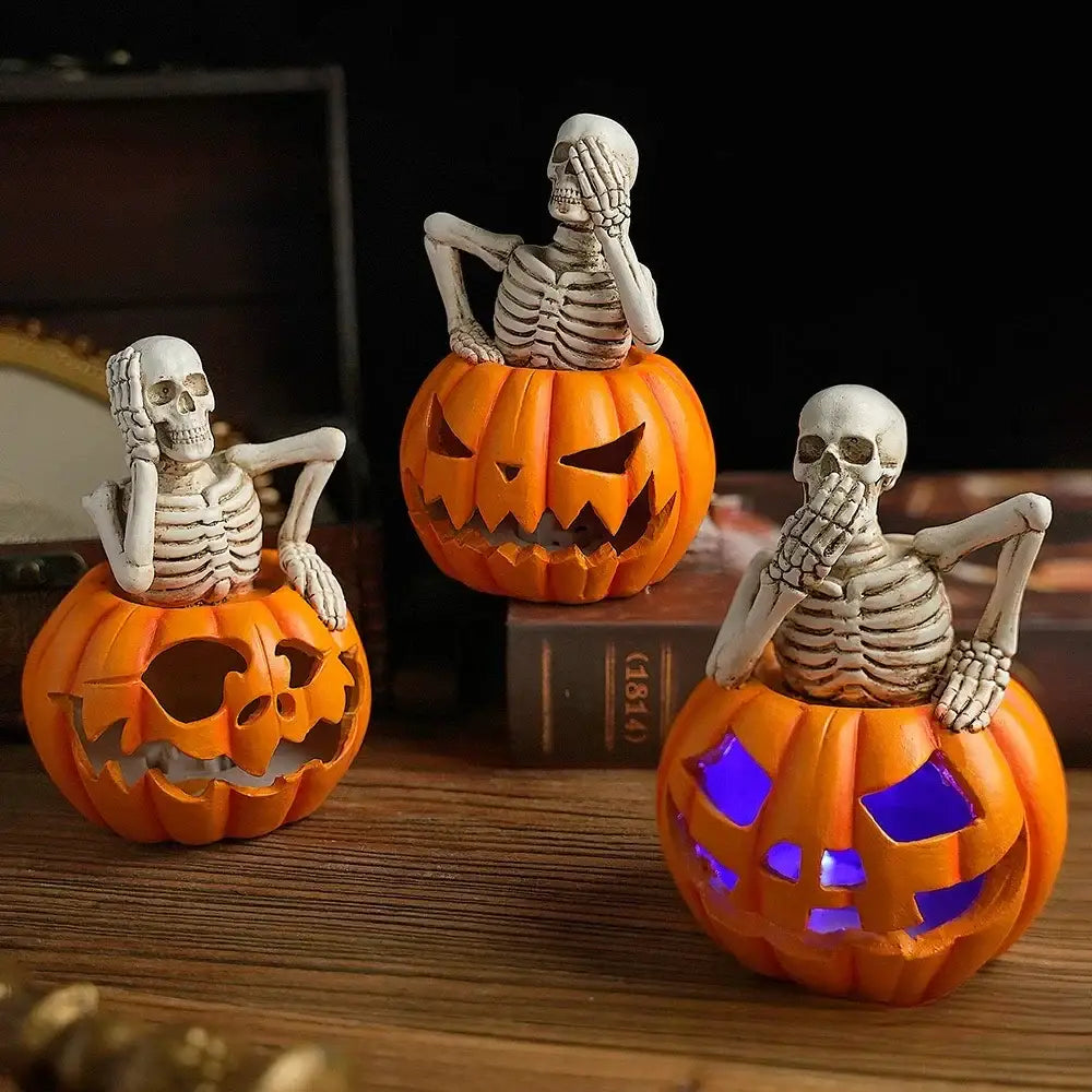 Three halloween-themed lighted skull pumpkin skeleton sculptures seated in orange pumpkins with blue and purple lights