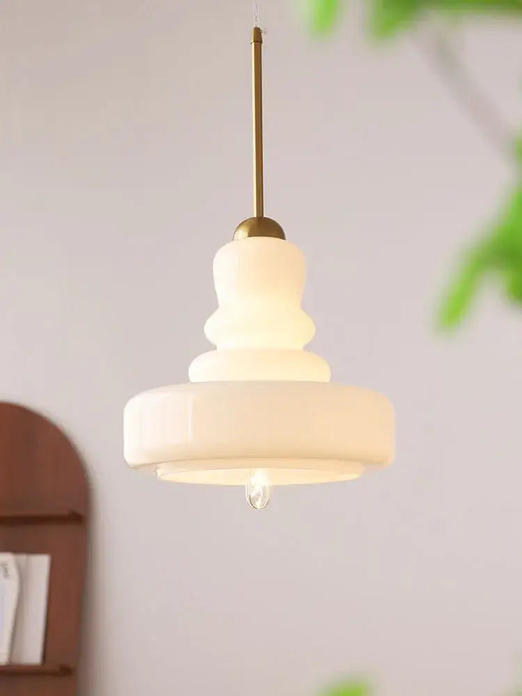 Cream-colored tiered glass pendant light with brass-finished rod complements lime green colorful gourd pendant lights