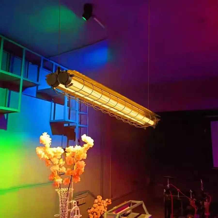 Linear chandelier glass pendant lamp featuring an industrial yellowish-gold metal housing with protective wire cage