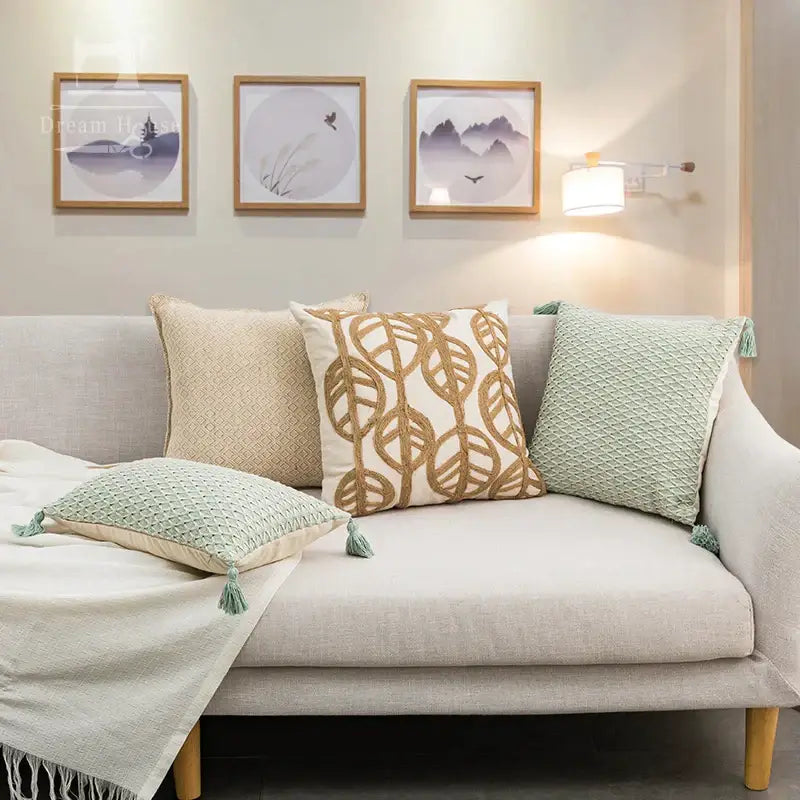 Beige linen sofa with wooden legs featuring decorbites linen embroidery leaves cushion cover in cream and beige tones