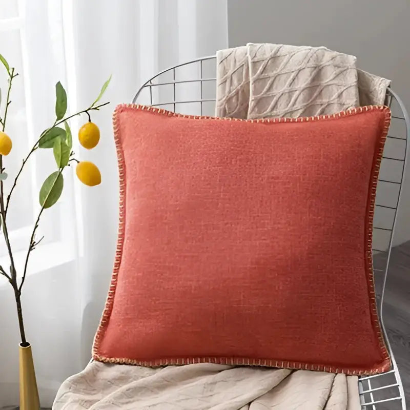 Coral-colored linen fringe cushion cover with textured woven fabric and neatly stitched edges for living room decorbites decor