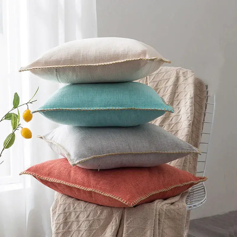Stack of four decorbites linen fringe cushion covers in soft neutral tones with natural stitched edges for living room decor