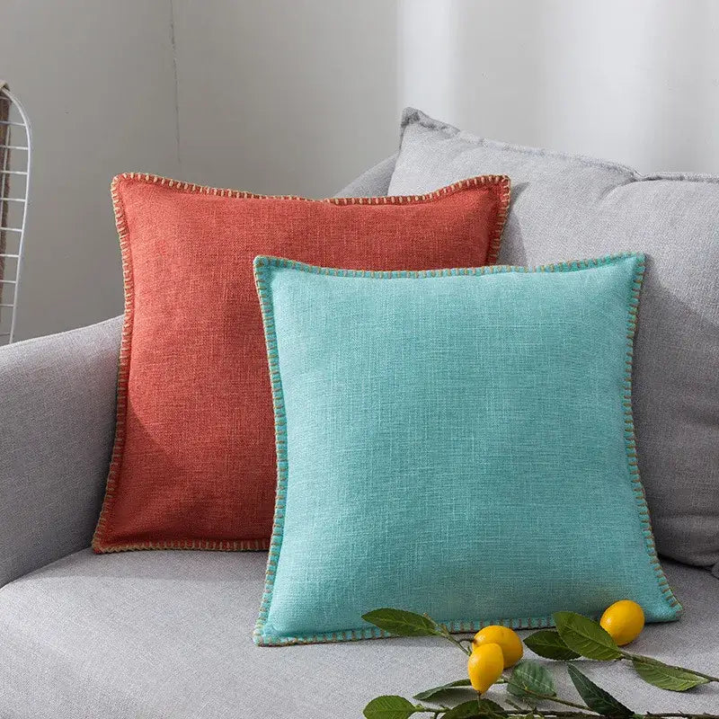 Two square cushion covers in terracotta and teal linen fringe featuring textured weave and contrasting stitched edges for decorbites linen fringe cushion