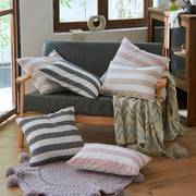 Gray upholstered sofa with wooden arms and legs featuring decorbites linen stripe cushion covers in black-white and pink-cream patterns