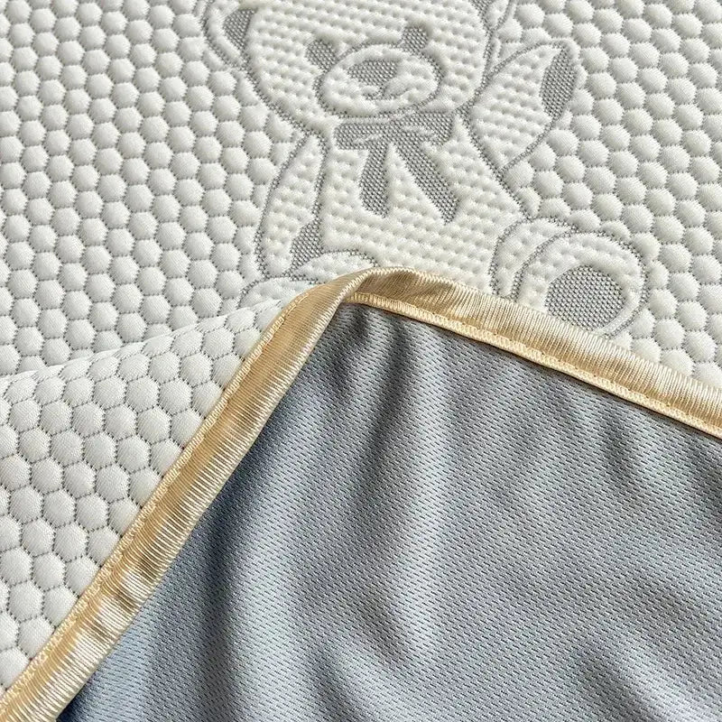 White quilted bedroom mattress pad with gray embroidered teddy bear and gold trim bear jacquard cooling mat