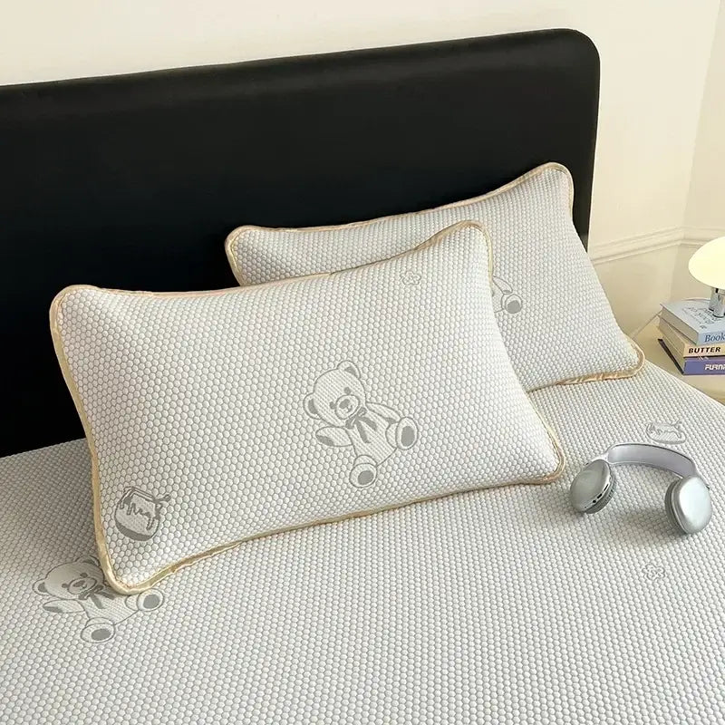 White textured pillow with gray teddy bear embroidery and beige piping on little bear gray jacquard cooling mat