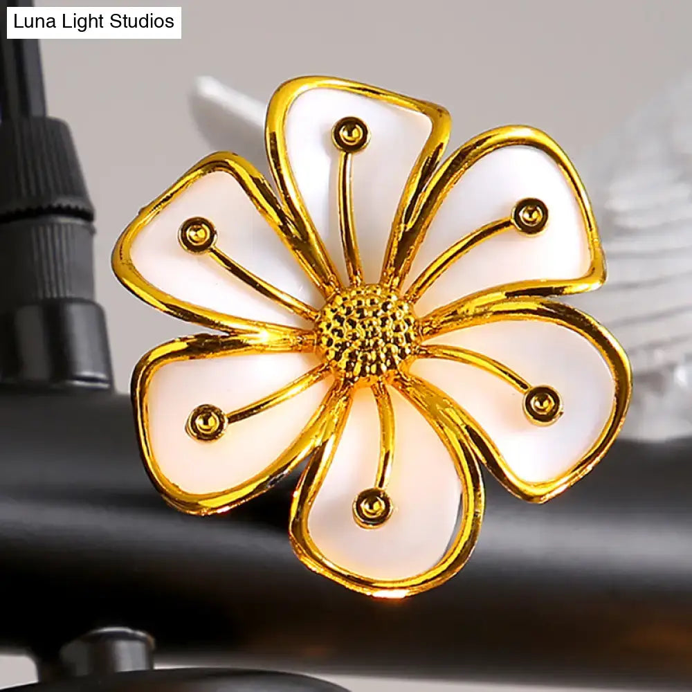 Gold-toned flower-shaped air freshener with white translucent petals complements DecorBites pendant light with clear crystal cylinder
