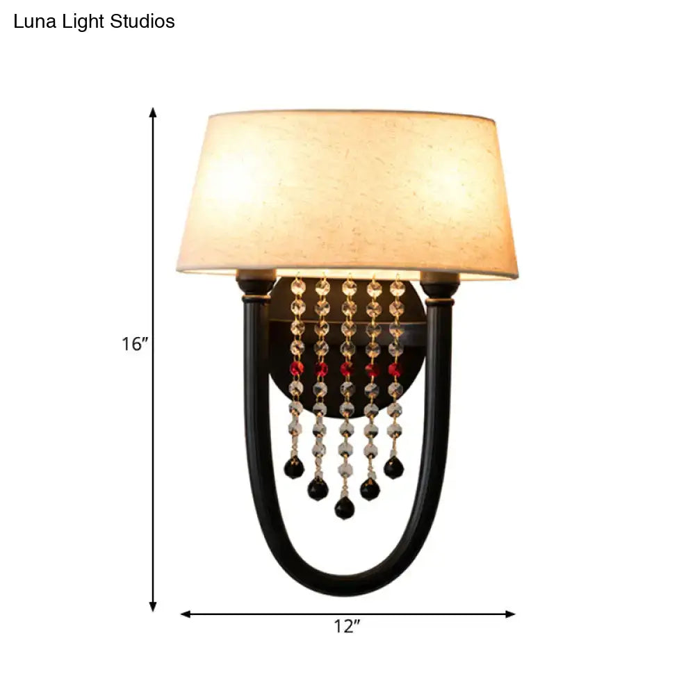Lodge black fabric drum wall lamp with beige fabric shade and cascading clear red and black crystal beads