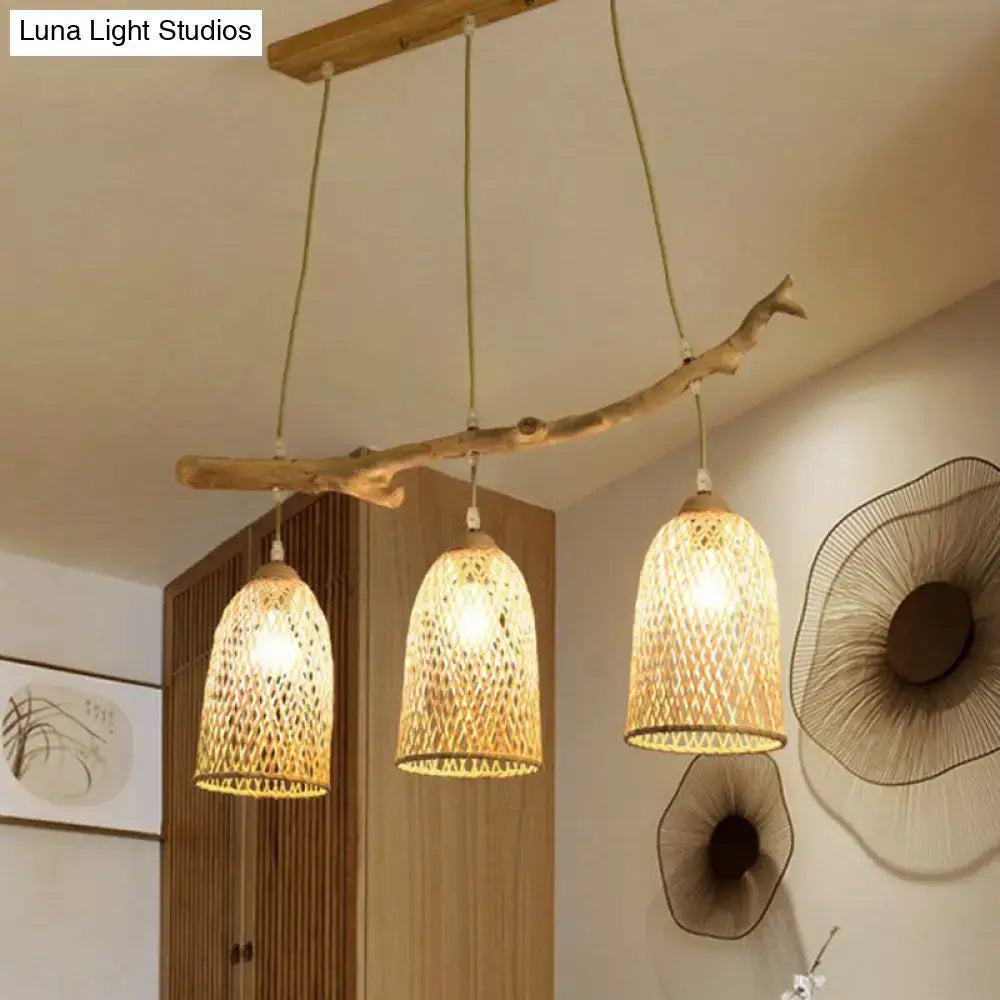 Lodge style wood pendant light featuring a natural wood branch with three woven rattan shades for dining room