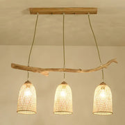 Lodge style wood pendant light featuring natural wood branch and three woven rattan shades for dining room