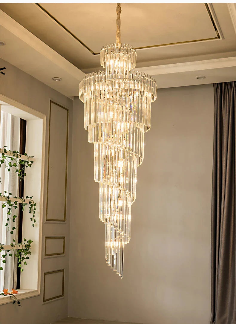 A multi-tiered crystal staircase gold chandelier with cascading prisms suspended by a gold chain for hotel hall decor