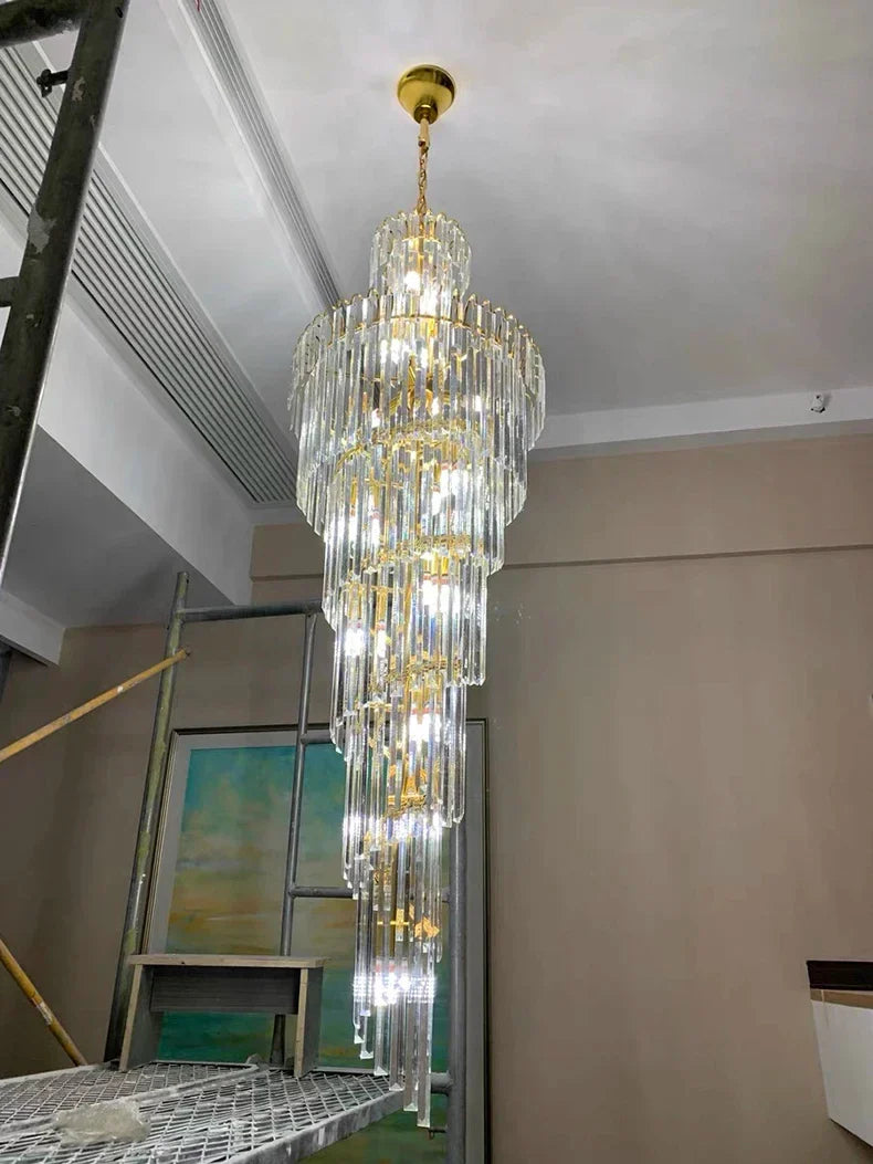 A multi-tiered crystal staircase gold chandelier with cascading clear glass rods for luxury hotel hall decor