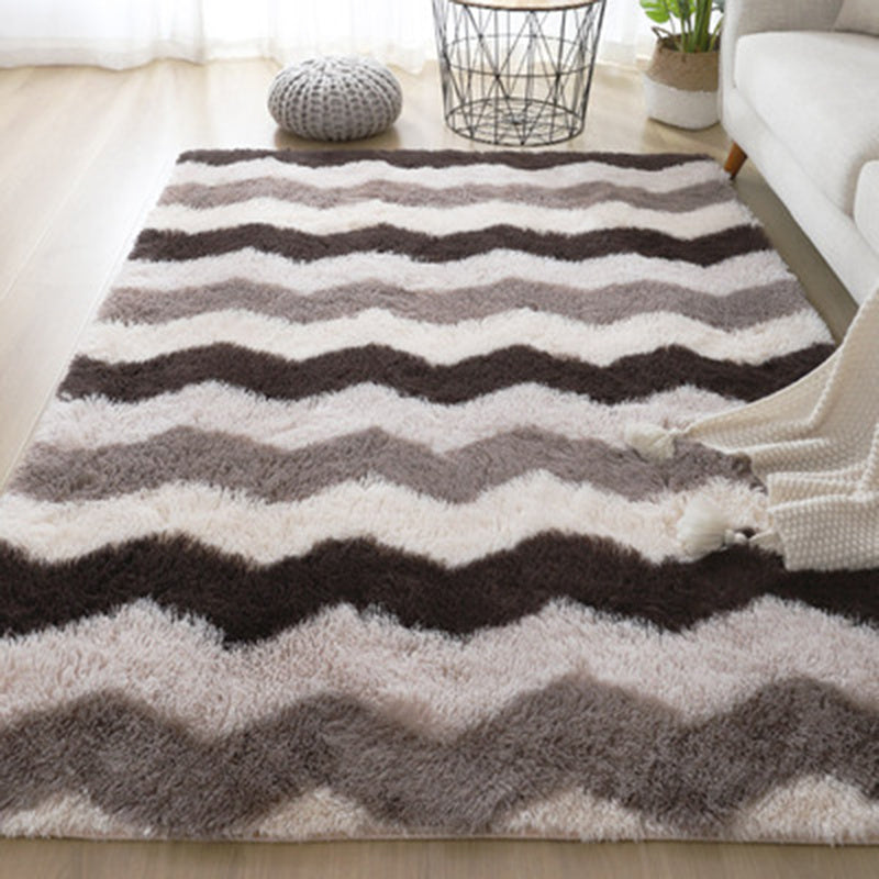 Chevron patterned rug with brown, gray and white stripes on a plush texture.