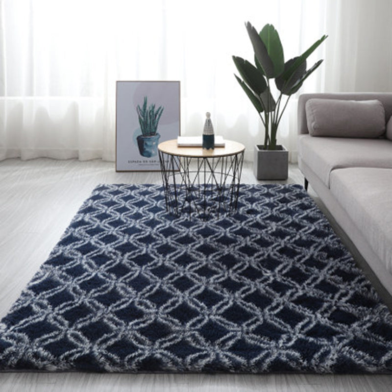 Navy blue area rug with white geometric pattern, plush texture, and modern design.