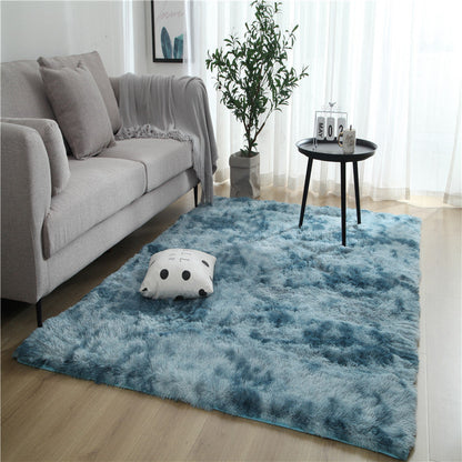 Blue fluffy rug with a tie-dye pattern and soft texture.
