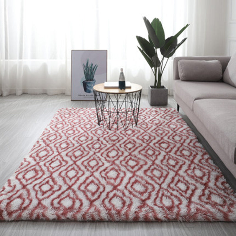Red and white geometric patterned rug with a plush texture.