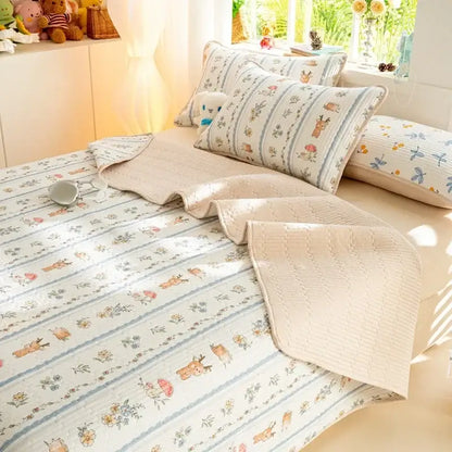 Beige quilted mattress mat with decorbites cartoon pattern of deer and floral motifs in muted blues and browns cotton