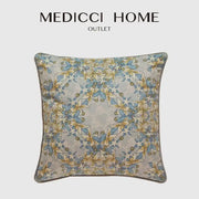 A square luxe blue and gold camellia floral velvet cushion cover from medicci home outlet with an elegant symmetrical floral pattern on beige background
