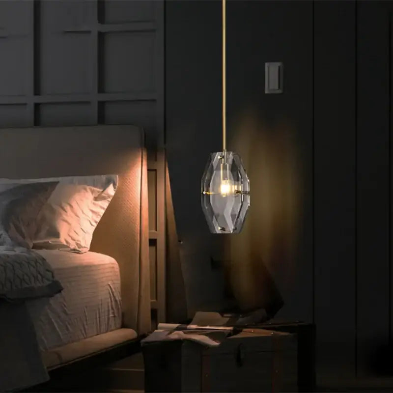 Luxe faceted gold crystal glass pendant lamp with gold-toned chain hangs above bed warm illumination decorbites crystal glass pendant lamp