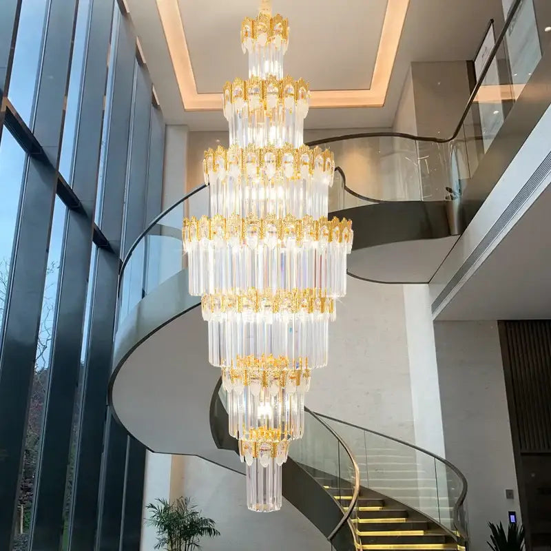 Luxurious gold and clear decorbites crystal staircase chandelier with cascading crystal tubes and ornate metalwork