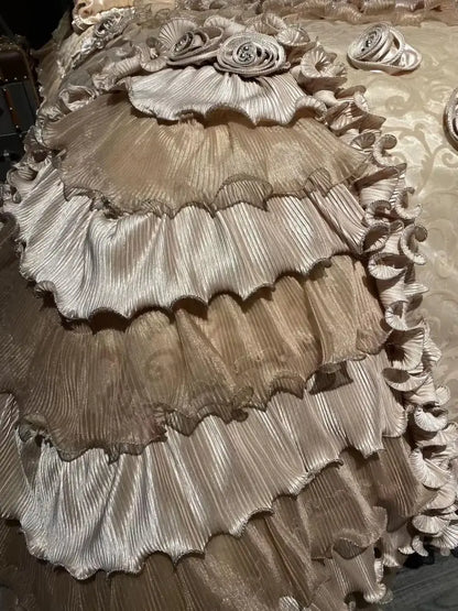 A luxurious multi-tiered gown in shimmering metallic gold with pleated ruffles complements decorbites jacquard rose lace bedding set