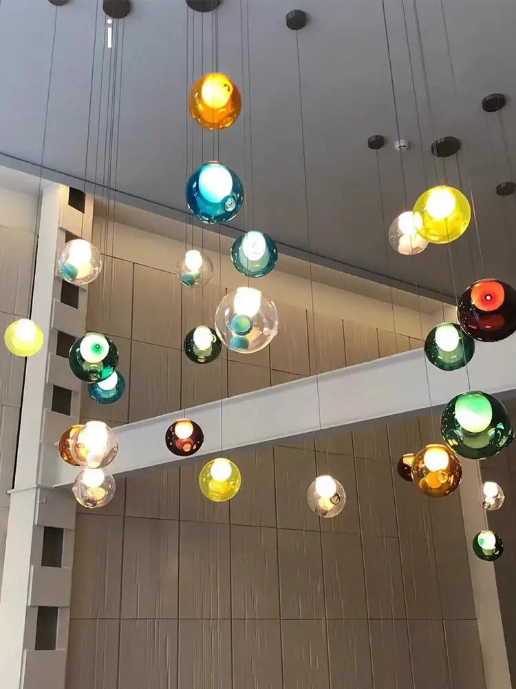 Luxury amber glass sphere pendant light with colorful clear glass pendant globes hanging in modern dining room decorbites design