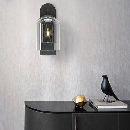 Luxury amber glass wall art light featuring a black wall-mounted sconce with a clear glass dome and exposed filament bulb