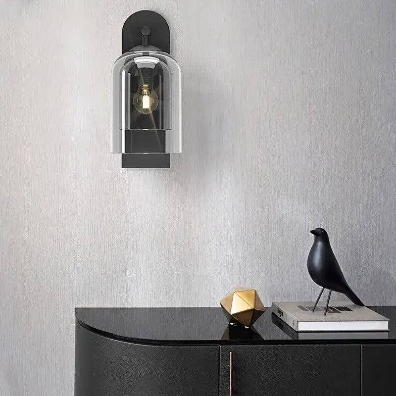 Luxury amber glass wall art light featuring a black wall-mounted sconce with a clear glass dome and exposed filament bulb